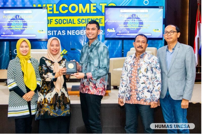Dekan Fisipol memberikan cinderamata kepada Azlan Abbas.