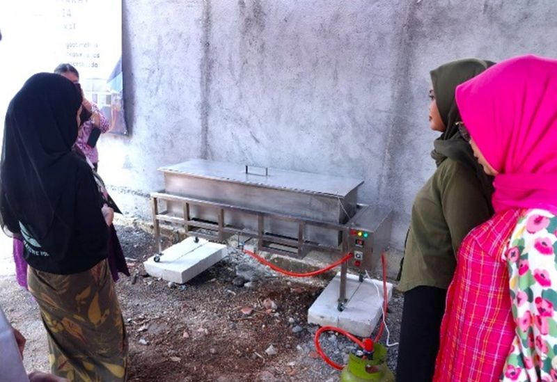 Tim dosen UNESA memberikan pengarahan dan pendampingan seputar cara menggunakan mesin steamer kepada UKM Daun Efek.